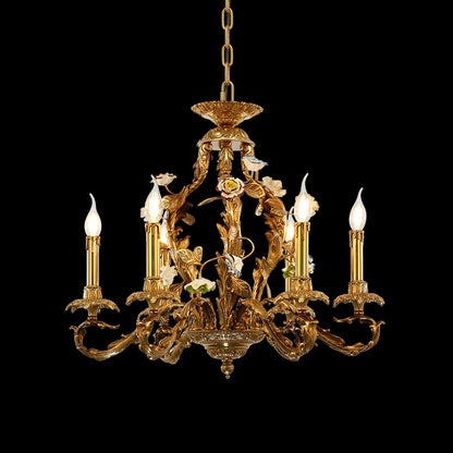 Decorative brass chandelier with bird figurine and ceramic flowers, featuring six candle bulbs.