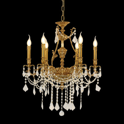 A golden brass chandelier with crystal strands, suspended by chains against a plain wall.