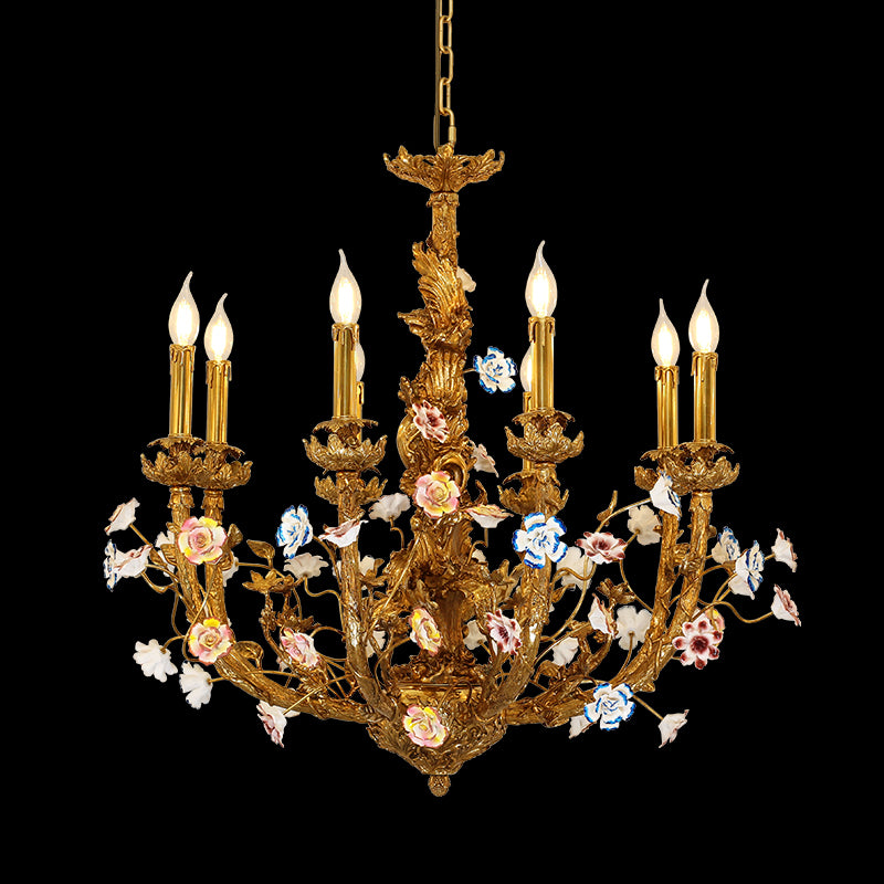 Close-up of Pompadour's Porcelain Bloom brass chandelier with multi-colored ceramic flowers on black.