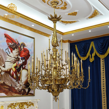 Extreme close-up of the intricate central medallion with a face and leaf carvings on a brass chandelier.