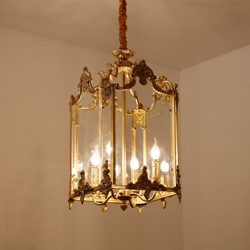 Cage-style brass pendant light with detailed metalwork, displayed on a plain interior wall.