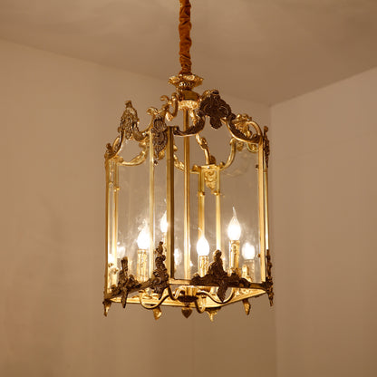 Cage-style brass pendant light with detailed metalwork, displayed on a plain interior wall.