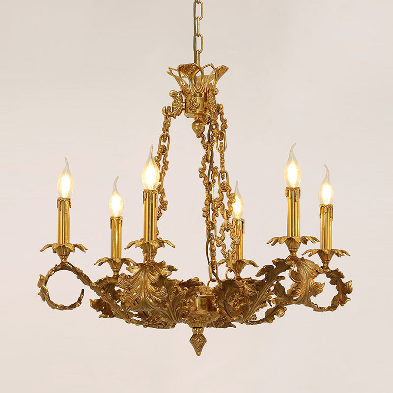 Lit French-style brass chandelier with six candle lights and ornate metalwork.