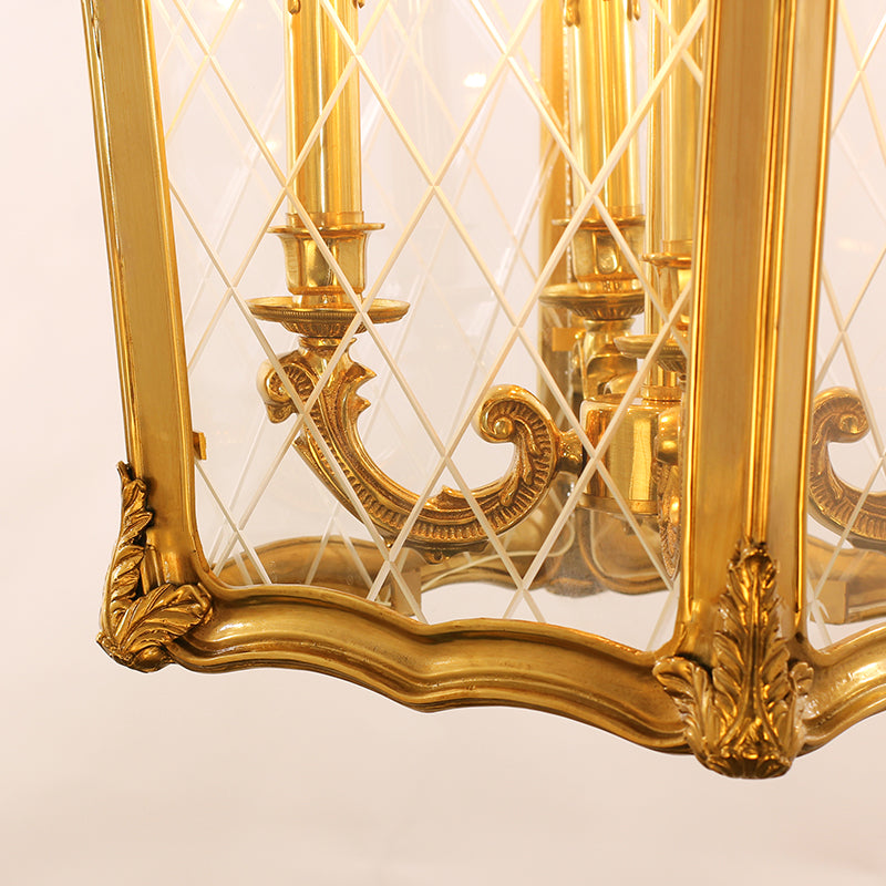 Extreme close-up of the diamond-patterned glass and ornate brass corner detail on the pendant light.