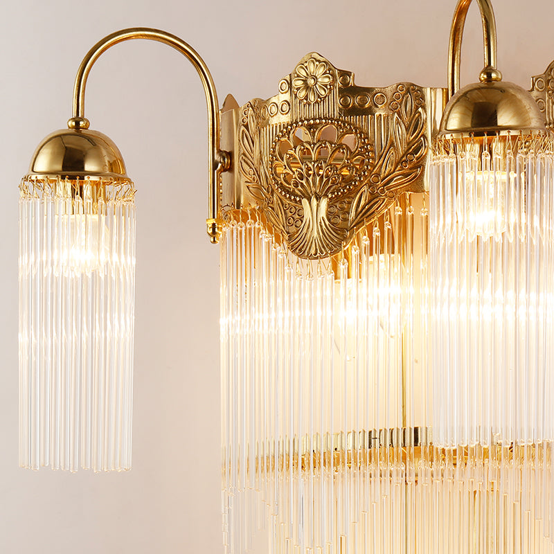 Detailed macro shot of the crystal fringe and the polished brass arm of the French-style wall light.
