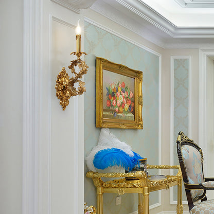 The installed French brass wall lamp on a white wall, paired with a floral oil painting and feather decoration.
