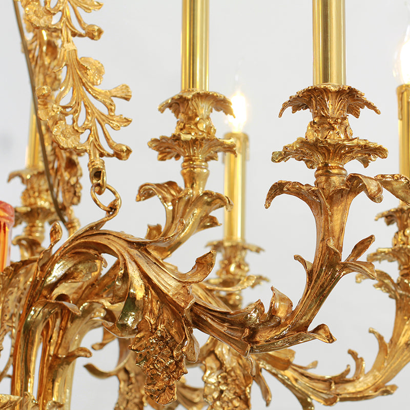 Macro detail of ornate brass scrollwork and a glowing candle bulb on a decorative chandelier arm.