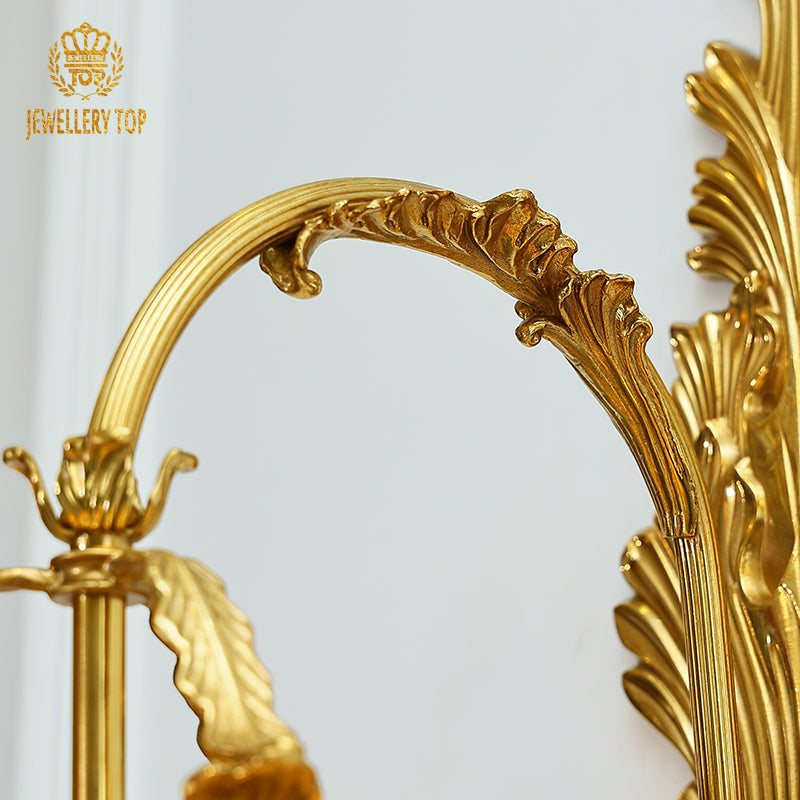 The grand brass wall lamp installed on a luxurious marble-textured wall in a opulent hallway or lobby setting.