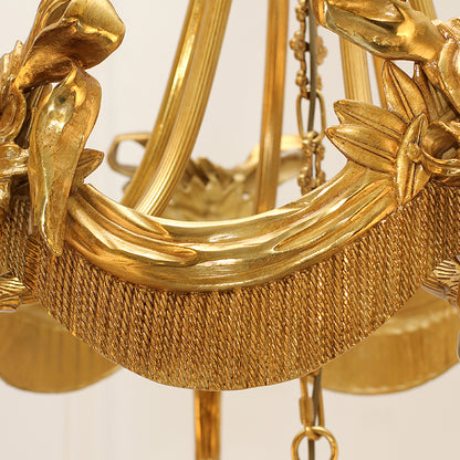 Macro close-up of the finely detailed wheat sheaf carvings and the textured woven pattern on the curved golden frame.