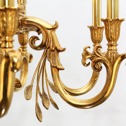 Macro detail of a curved brass arm with intricate scrollwork and classical motifs.