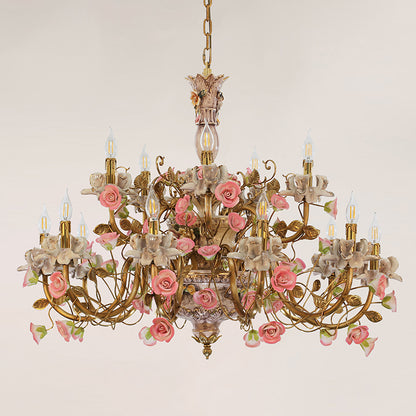 Multi-arm brass chandelier with ceramic floral decorations, displayed on a light wall.