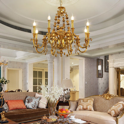 The brass chandelier installed in an elegant living room with sofas and a floral arrangement.