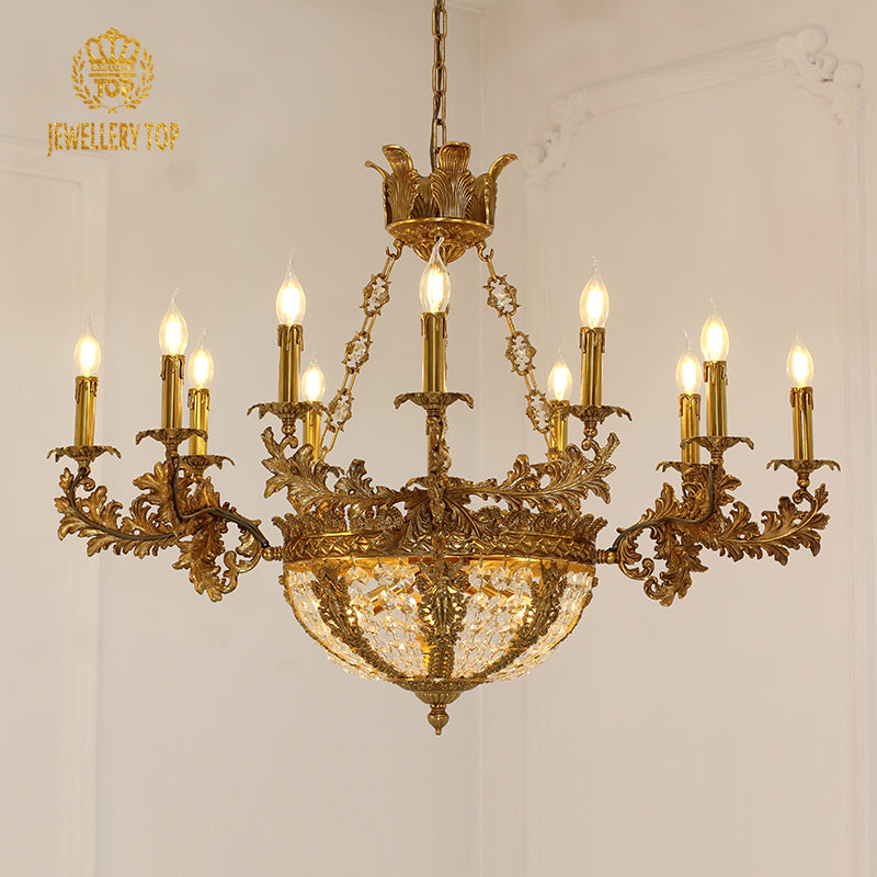 JEWELLERY TOP branded golden brass crystal chandelier against a white wall.