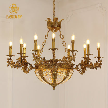JEWELLERY TOP branded golden brass crystal chandelier against a white wall.