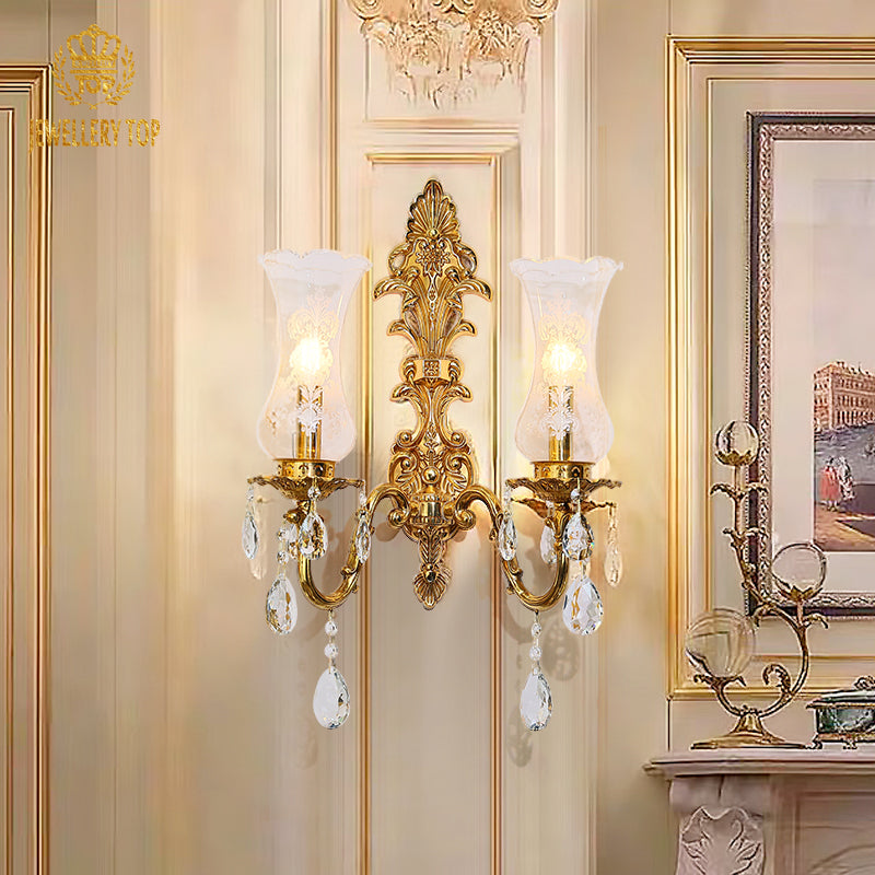 The French brass wall lamp installed on a light-colored wall, emitting a warm glow beside decorative art.