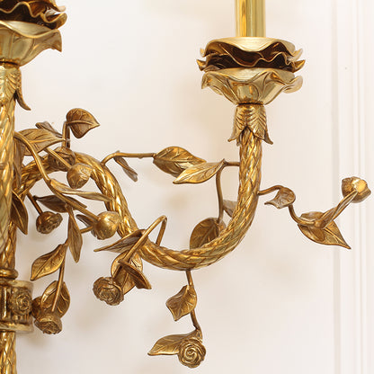 Macro detail of a single curved arm, highlighting the hand-carved grape clusters and textured leaves on the wall lamp.