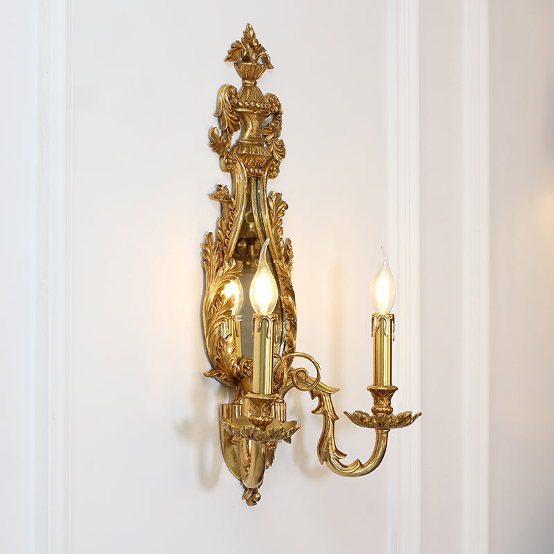 Extreme close-up of the polished brass scrollwork, leaf details, and the surface of the integrated mirror.