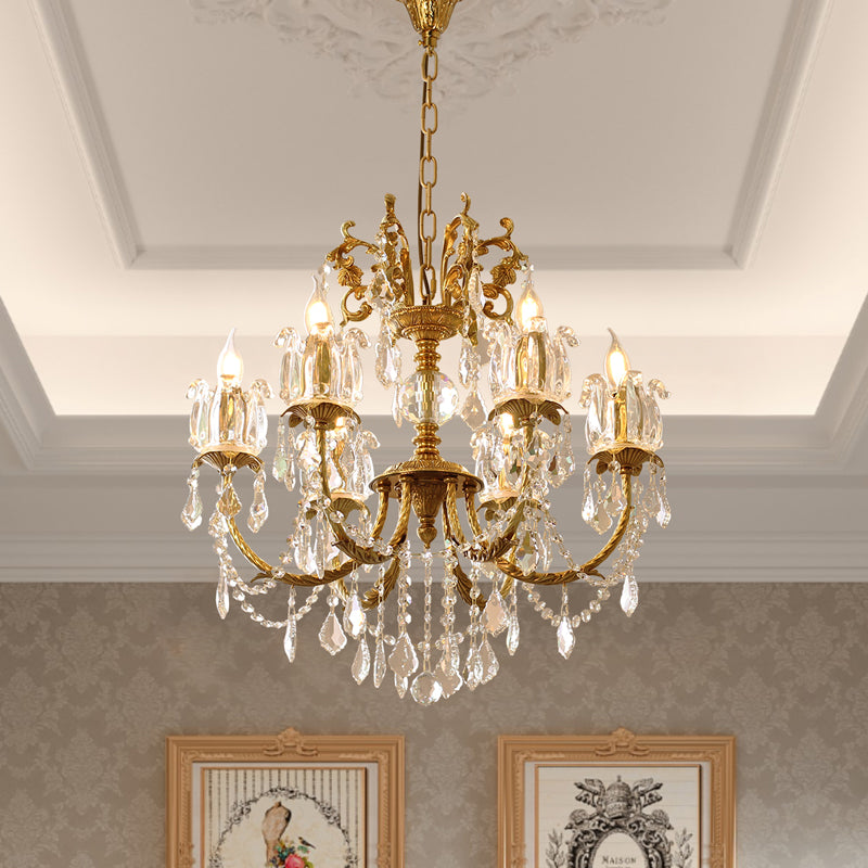 The crystal brass chandelier installed on a decorative ceiling with patterned wall and artwork.