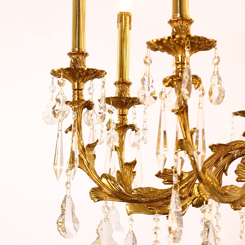 Extreme close-up of ornate brass scrollwork and hanging teardrop crystal prisms.