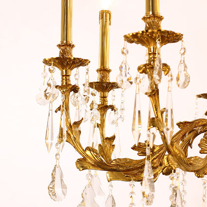 Extreme close-up of ornate brass scrollwork and hanging teardrop crystal prisms.