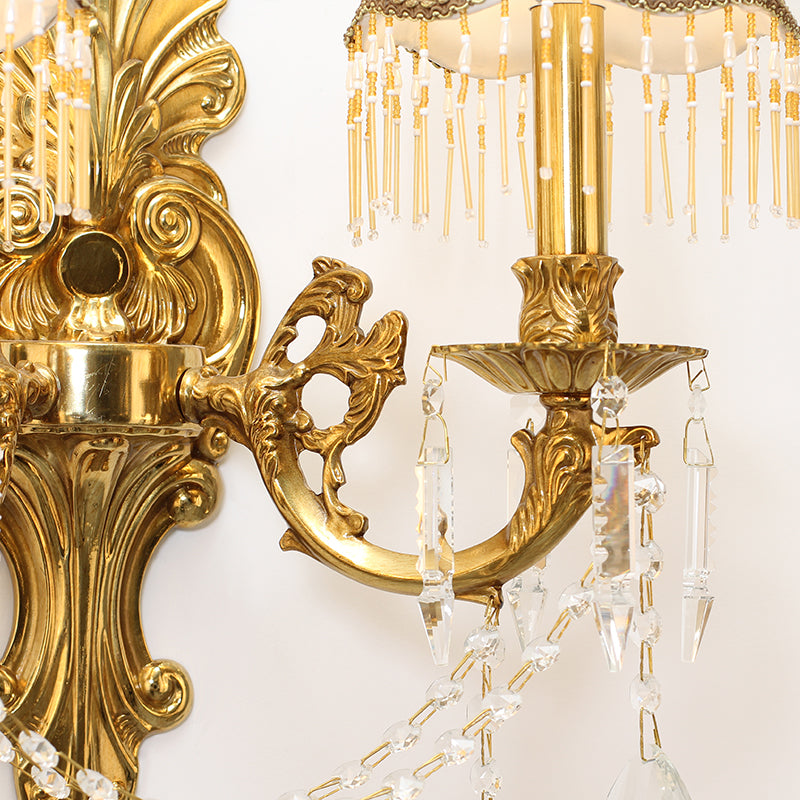 Detailed shot of a single pleated ivory fabric lampshade with dark trim and hanging crystal fringe.