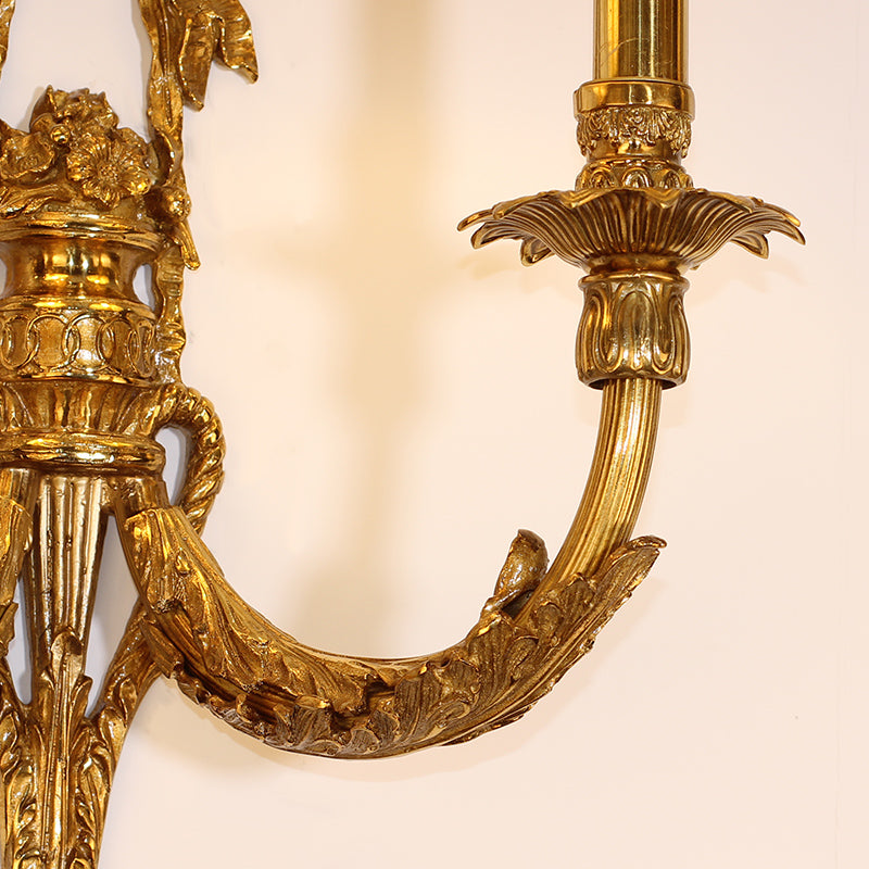 Detailed focus on the sculpted brass bow decoration and the texture of the pleated fabric lampshade.