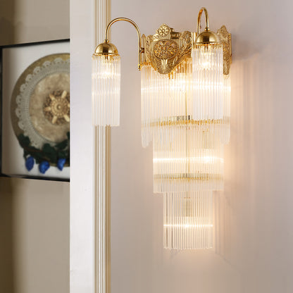 The classical crystal wall light installed on a light wall beside framed art, emitting a warm, luxurious glow.