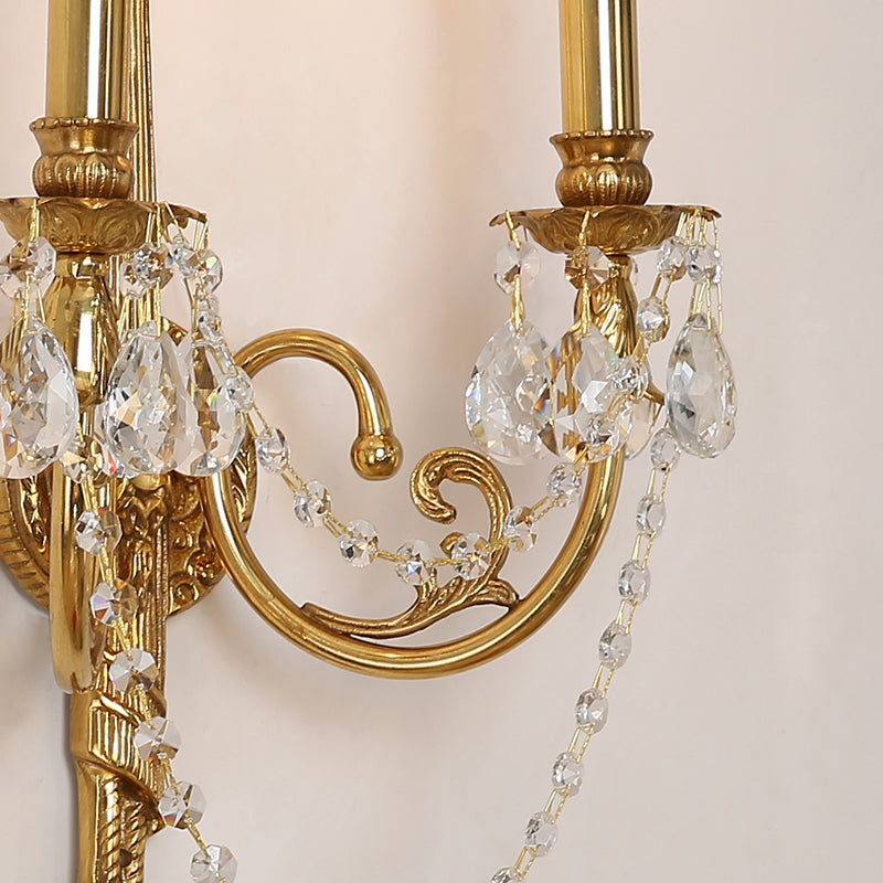 Extreme close-up of the sconce’s patinated metalwork, leaf relief, and teardrop crystal strings.