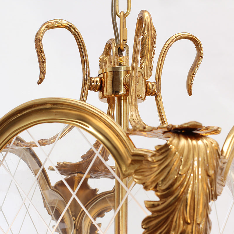 Macro shot focusing on the intricate brass scrollwork and golden finish of a luxury pendant light.