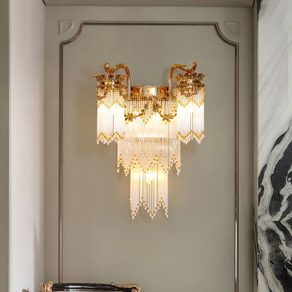 The luxury crystal wall light installed on a light gray wall with panel molding, illuminating the space with a warm, sparkling glow.