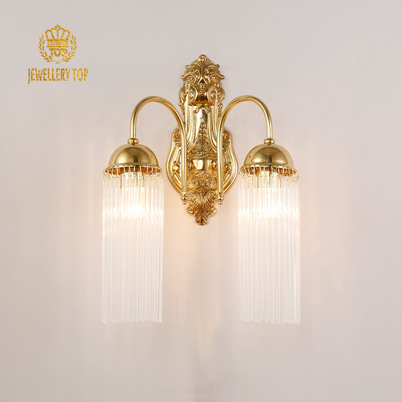Close-up detail of the ornate brass scrollwork and crystal strands on the sconce.