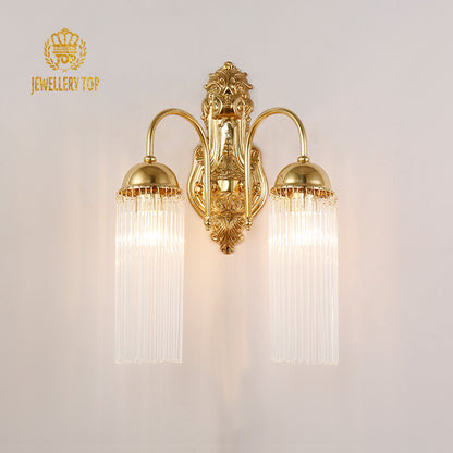 Close-up detail of the ornate brass scrollwork and crystal strands on the sconce.