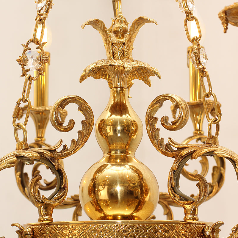 Top detail view of the chandelier’s fluted brass column and ornate canopy.