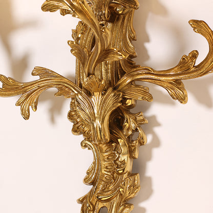 Extreme close-up macro detail of the sconce’s central filigree, featuring scrolls, leaves, and openwork patterns.