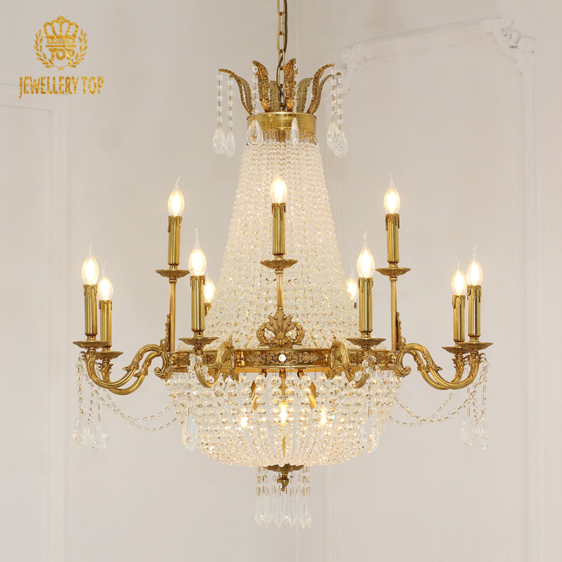 JEWELLERY TOP brand's golden brass chandelier with crystal fringes against a white wall.