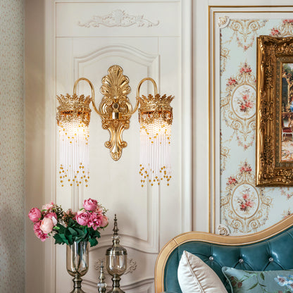 The installed luxury Victorian brass wall lamp on a white paneled wall beside a gold-framed floral painting.