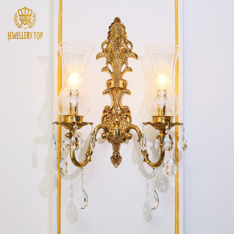 Branded close-up (JEWELLERY TOP) of the golden wall sconce showcasing intricate fan-shaped metalwork.