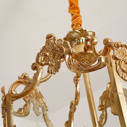 Extreme close-up of ornate scroll and floral carvings on the brass arm of a pendant light.