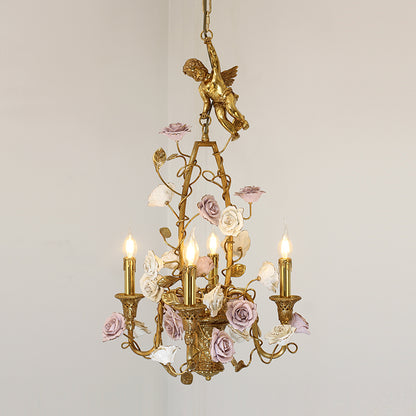 Macro close-up of the cherub sculpture and the hand-painted white and blush pink roses intertwined with the brass frame.