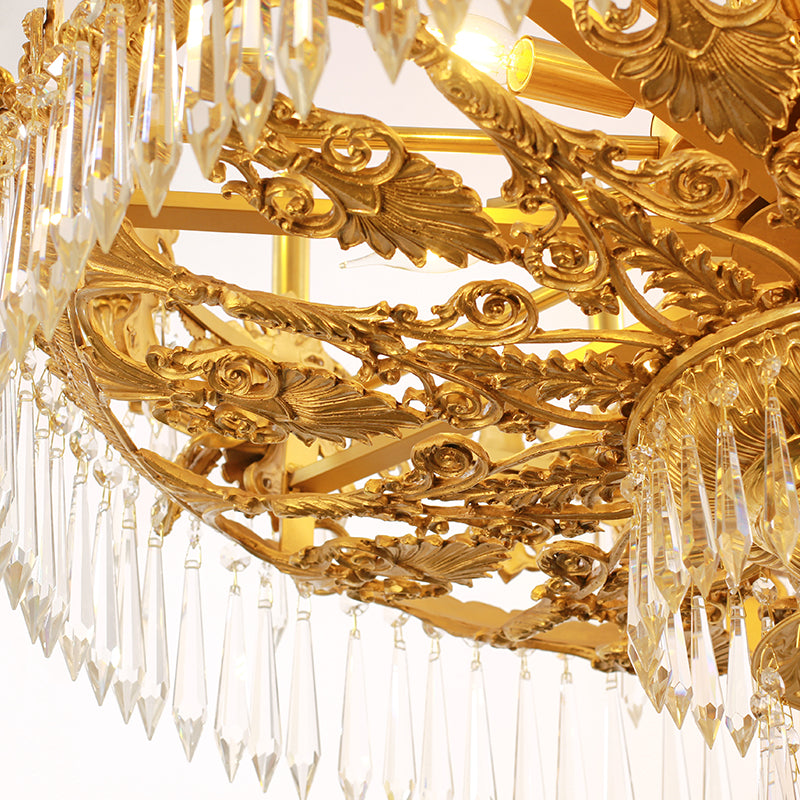 The lower section of a grand brass chandelier, highlighting the dense fringe of crystal drops.