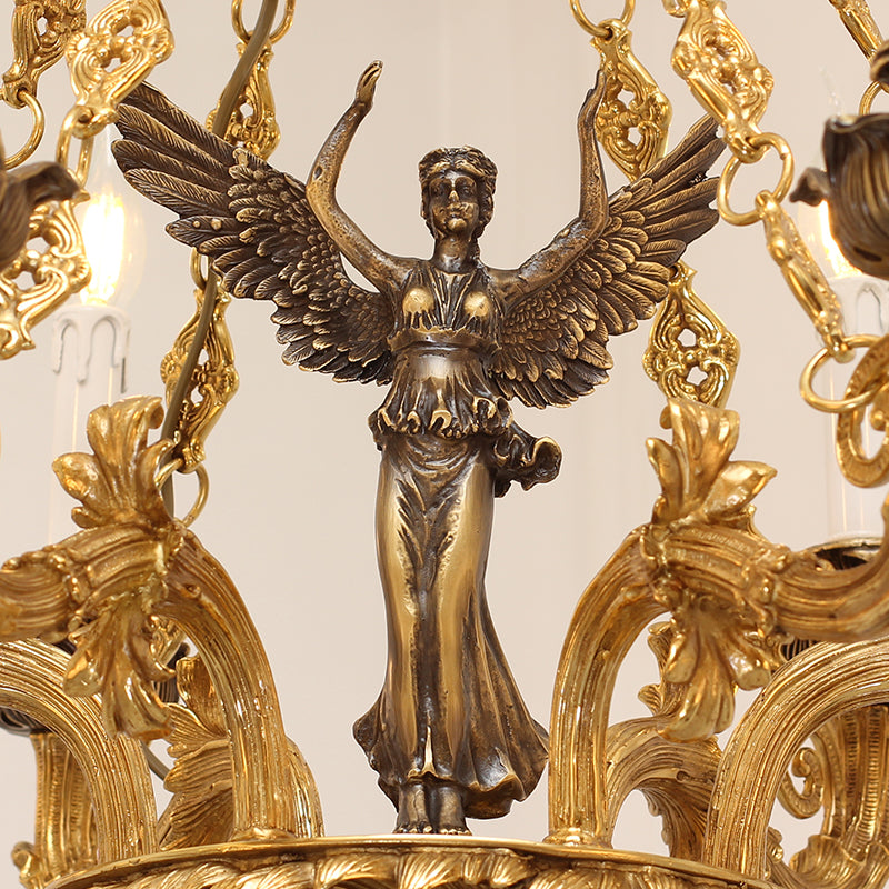 Detailed macro shot of the winged victory goddess statue central to the decorative brass chandelier.
