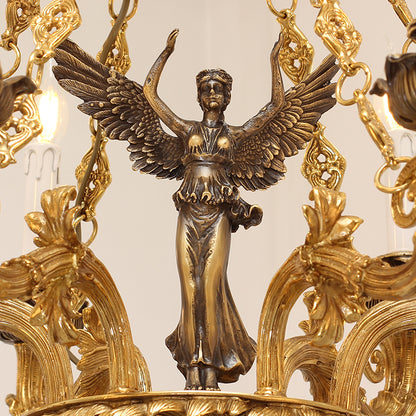 Detailed macro shot of the winged victory goddess statue central to the decorative brass chandelier.