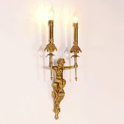 The installed traditional two-light wall sconce emitting a warm glow on a white paneled wall next to decorative molding.