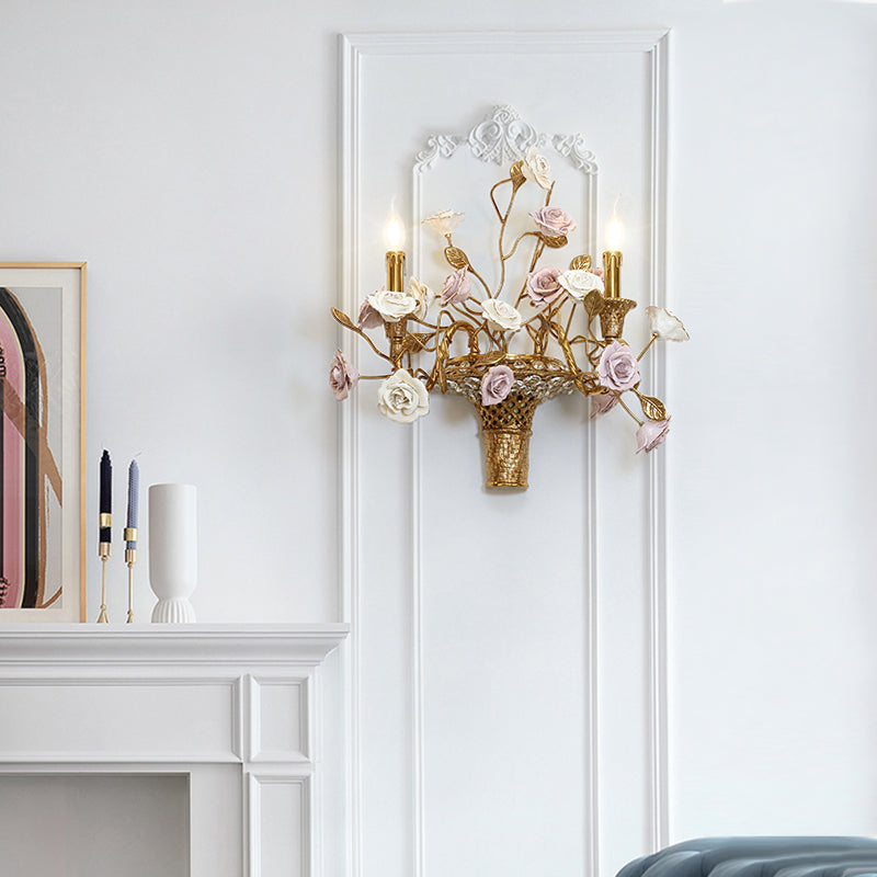 The brass and ceramic wall sconce installed on a white wall next to a fireplace and decorative artwork, showcasing its home decor appeal.