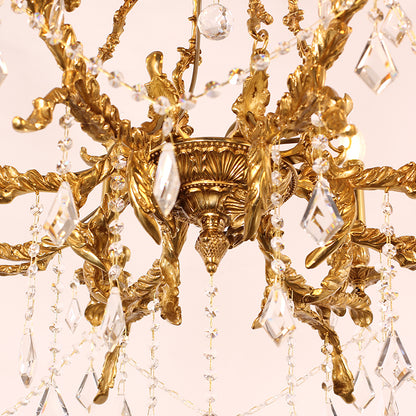 Macro shot of the chandelier's central brass scrollwork and cluster of teardrop crystals.