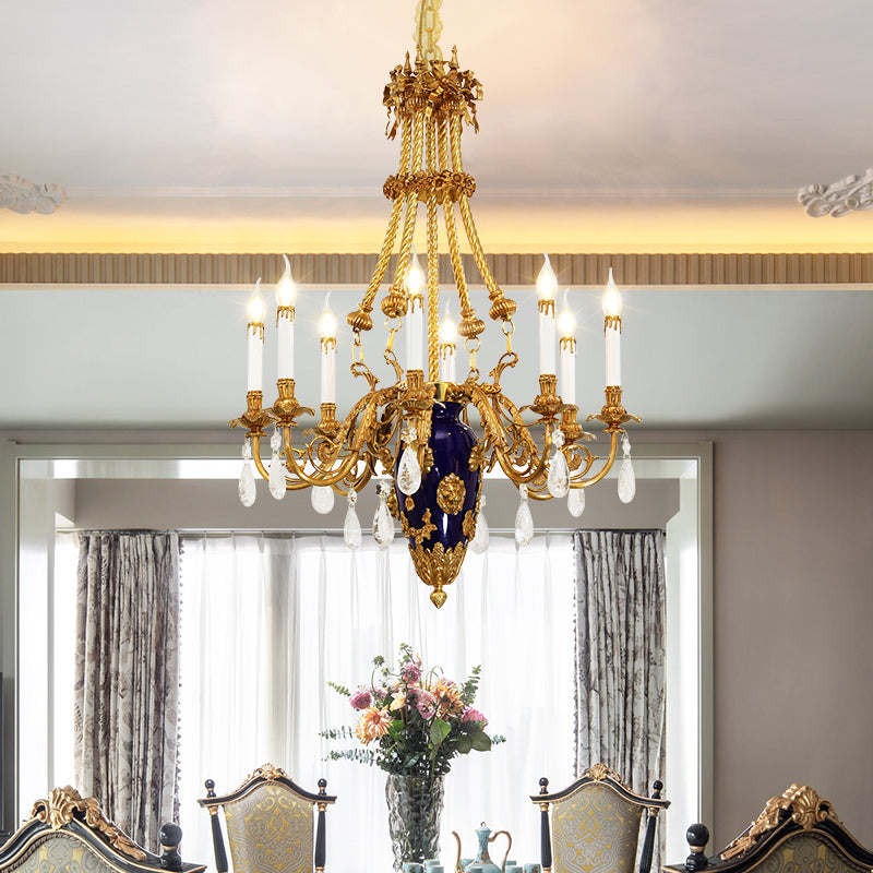 JEWELLERY TOP's luxury brass chandelier illuminating a formal dining room with flowers and chairs.