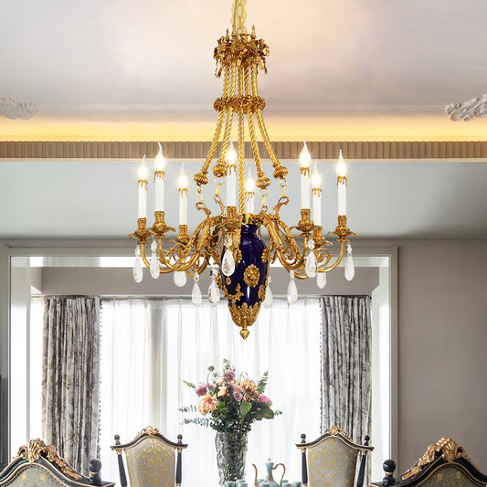JEWELLERY TOP's luxury brass chandelier illuminating a formal dining room with flowers and chairs.