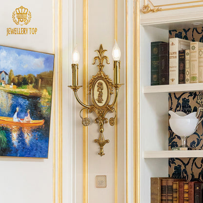 The antique bronze wall light installed on a white wall beside a landscape painting and bookshelf, emitting warm light.