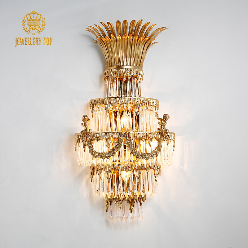 JEWELLERY TOP branded close-up of the golden brass sconce, highlighting intricate metalwork and glowing bulbs.