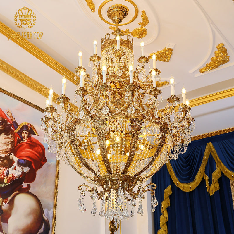 Ornate French brass crystal chandelier in an opulent room with gold trim and red artwork.
